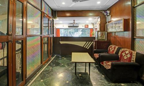 加尔各答Treebo Trend Mira Inn的一间房间,设有两张沙发和一张火车桌