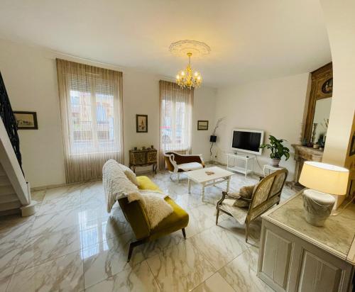 兰斯Magnifique maison d’artiste的客厅配有沙发、椅子和电视