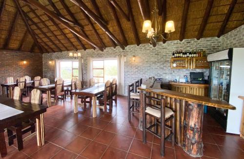阿多Charihandra Game Lodge的一间带桌椅的餐厅和一间酒吧