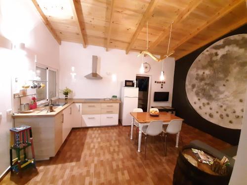 IsoraCASA LA LUNA的厨房配有白色橱柜和木桌