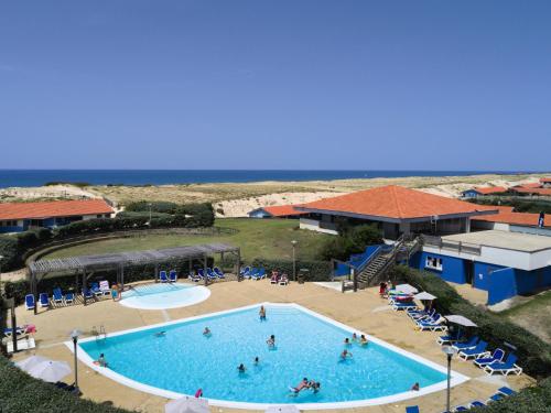 塞尼奥斯Belambra Clubs Seignosse Les Estagnots的享有游泳池的顶部景色,背景是大海