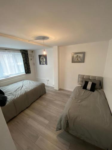 伦敦Lovely 3 Bedroom Apartment in the Heart of Hackney的一间卧室设有一张床和一个窗口