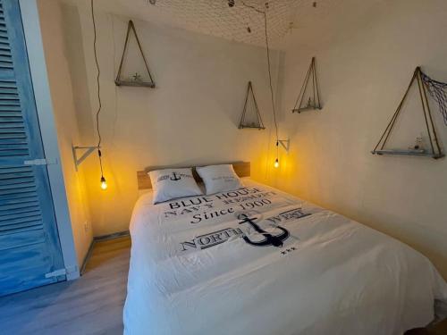 伊泽尔河畔的罗曼Ocean ROOM的一间卧室配有白色床单和灯。