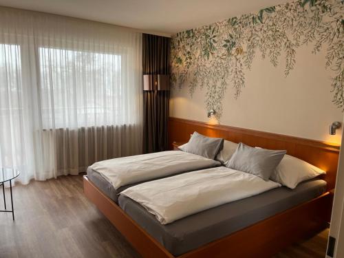 瓦瑟堡盖茨豪斯祖兰酒店的一间卧室配有一张大床和木制床头板