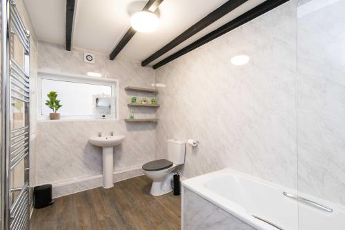 达宁顿堡✰Excellent 3 bedroom House - Close To Airport的浴室配有卫生间、盥洗盆和浴缸。