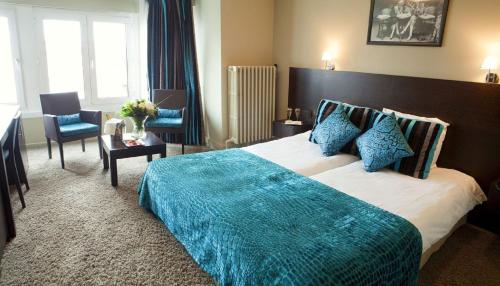 克诺克－海斯特The Memlinc的一间卧室配有一张带蓝色毯子的大床