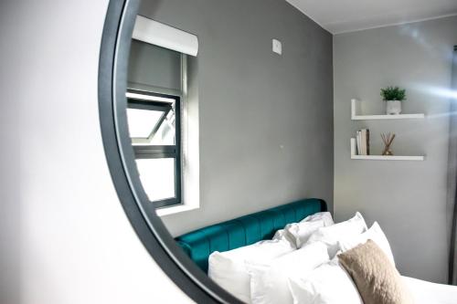 约翰内斯堡“Pop Inn” modern apartment in heart of Bryanston的镜子反射着房间里的床