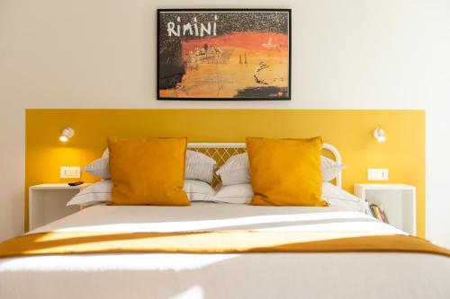 里米尼Corso51 Suite Apartments的一间卧室配有一张带黄色枕头的大床