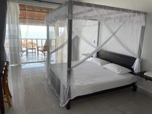 马拉维拉ISAMAR FRONT BEACH的一间卧室设有一张天蓬床,享有海景