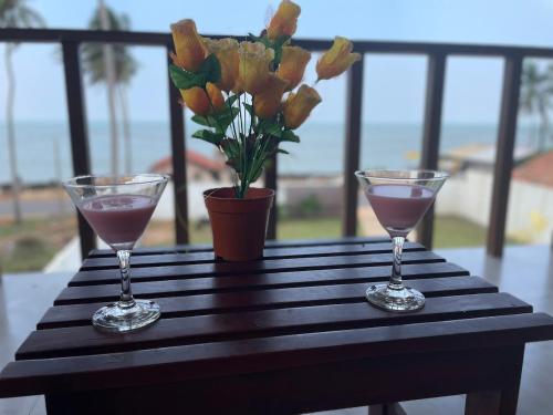 马拉维拉ISAMAR FRONT BEACH的桌上放着两杯酒,花瓶