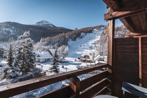 圣沙夫雷Grand Hôtel & Spa NUXE Serre Chevalier的从雪地滑雪胜地的阳台上欣赏风景