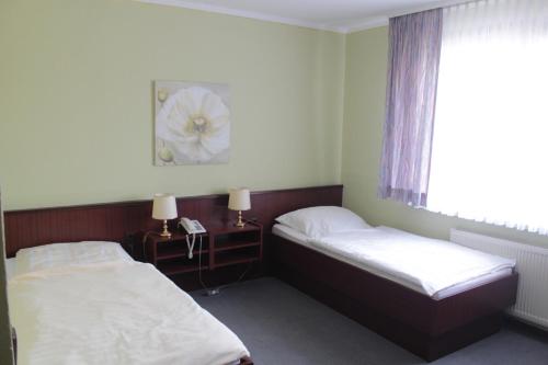 塞森Landhaus Zum alten Fritz的一间卧室设有两张床和一扇带花卉图案的窗户。