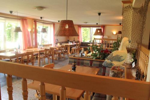 布雷格布雷格-博登旅馆的餐厅设有木桌、椅子和窗户。