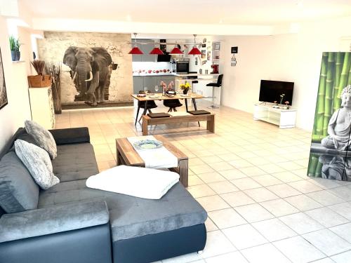 SamingAm Wildbach bei Passau的客厅配有沙发,墙上挂着大象