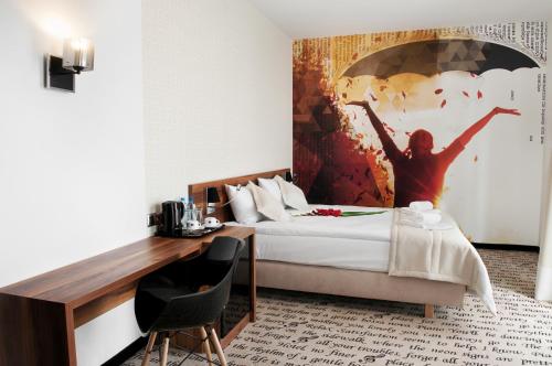 卢布林钢琴酒店的酒店客房的墙上设有一张带绘画的床铺。