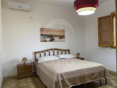 托雷拉皮罗Villa Sunshine的卧室配有一张床,墙上挂有绘画作品