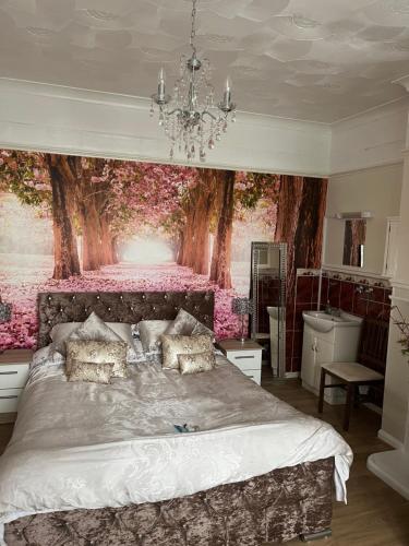 纽基茉莉花阁酒店的卧室配有一张大床,墙上挂有绘画作品