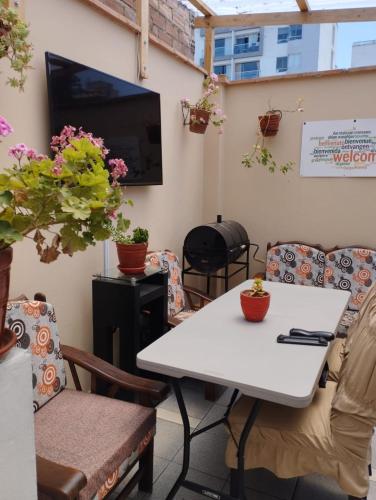 利马Dormitorio Independiente的配有桌椅和电视的客房