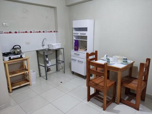 库斯科La casa de Chepita的厨房配有桌椅和冰箱。