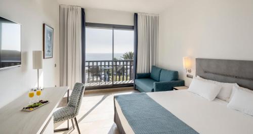 科尼尔-德拉弗龙特拉伊鲁尼卡拉斯科尼尔酒店的酒店客房设有一张床、一张书桌和一个阳台。