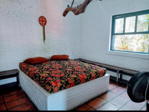 乌巴图巴Hostel Terra das Tribos的砖墙间内一间卧室,配有一张床