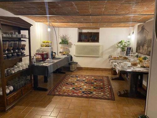 布雷谢洛B&B STAZIONE DON CAMILLO的一间厨房,内设两张桌子和一张地毯