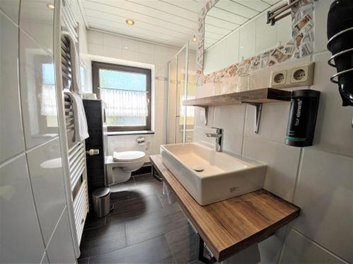 维林根Hotel Garni "Zur Alten Post"的一间带水槽和卫生间的浴室