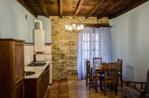 塔拉蒙迪Casas Rurales Taramundi Verde的厨房配有桌椅和窗户。