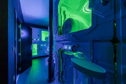 马德里Art Seven Hostel Capsules的蓝色和绿色的客房设有水槽和镜子