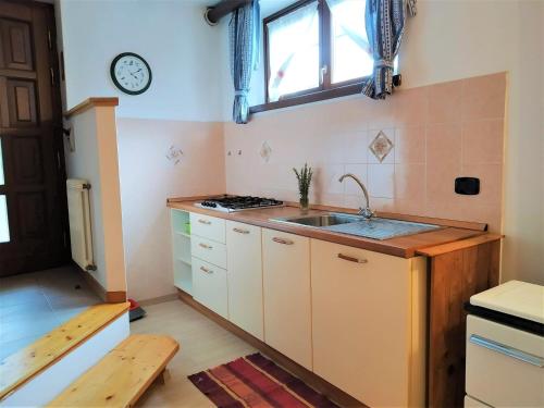 韦扎诺乐贝图勒公寓的厨房配有水槽和墙上的时钟