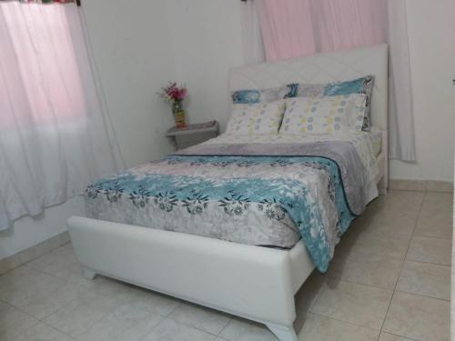 卡塔赫纳Casa ITCI Tours的卧室配有白色床和蓝色棉被