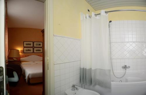 的里雅斯特哥伦比亚酒店的浴室配有浴缸、淋浴和水槽