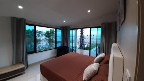 Ban Bo YaiLom Lay Beach Front Pool Villa Chaam, Huahin的一间卧室配有一张床,享有海景