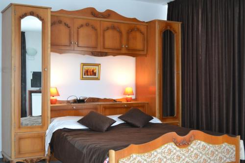 巴尔奇克玉兰家庭酒店的一间卧室配有一张带木制天篷的大床
