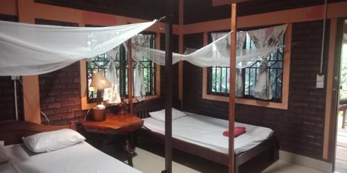 邦隆FamilyHouse & Trekking的一间卧室设有两张双层床和一张带台灯的桌子