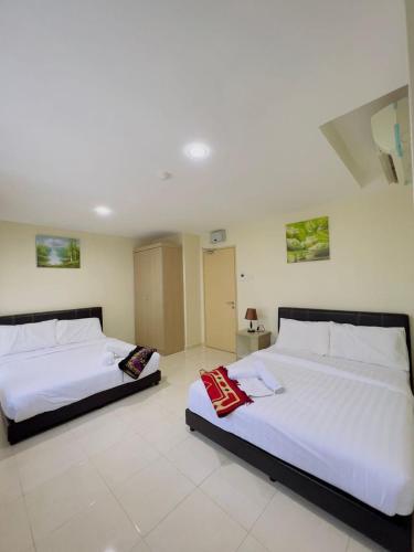 加央Noor Hotel Kangar的白色墙壁客房的两张床