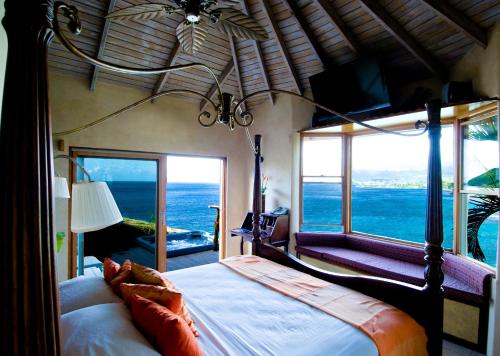 圣乔治马卡彼岸花度假酒店的一间卧室设有一张床,享有海景