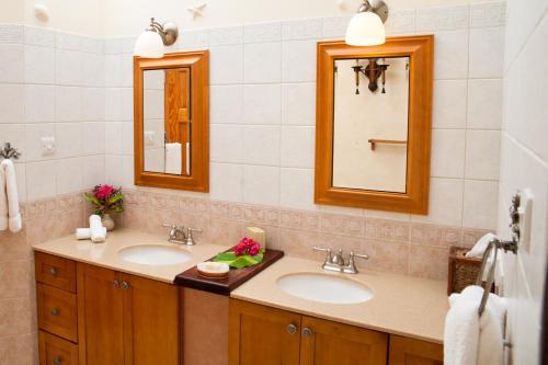 圣乔治马卡彼岸花度假酒店的浴室设有2个水槽和2面镜子