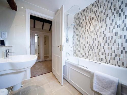 埃文河畔斯特拉特福Macdonald Alveston Manor Hotel & Spa的白色的浴室设有水槽、浴缸和水槽。