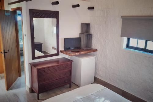 扎霍拉Hacienda Sajorami的小房间设有镜子、梳妆台和电视