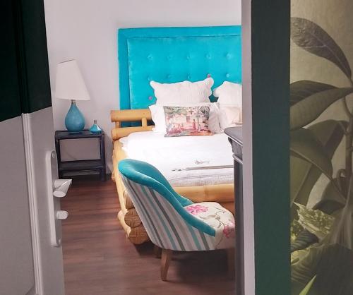圣路易斯Chambre confortable dans une ambiance hôtel de charme avec piscine的一间卧室配有一张蓝色床头板的床