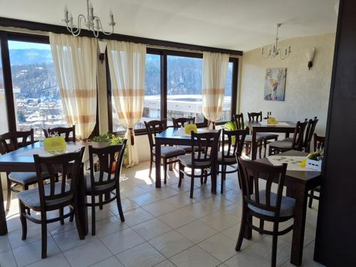 特里亚夫纳贝拉家庭酒店的用餐室设有桌椅和窗户。