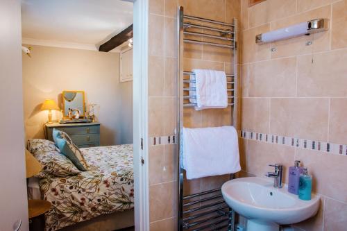 布由德利Whispering Place in the heart of Bewdley的带淋浴和盥洗盆的浴室以及1张床。