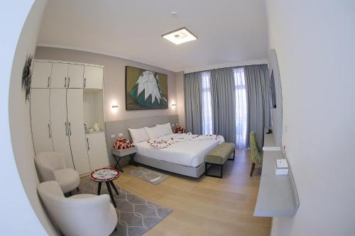 亚的斯亚贝巴Andromeda Hotel的配有一张床和一把椅子的酒店客房