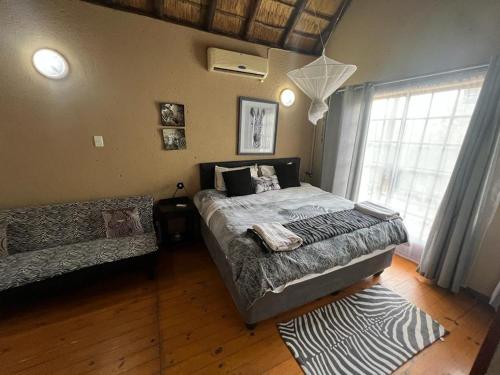 玛洛斯帕克Mopani Villa的一间卧室设有一张大床和一个窗户。