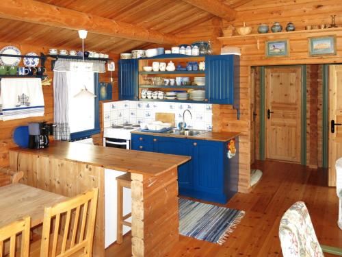 HolsenChalet Fjellro - FJS103 by Interhome的厨房铺有木地板,配有蓝色橱柜。