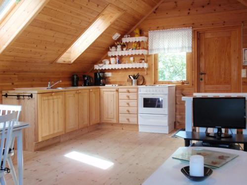 LundeHoliday Home Tufto - FJH659 by Interhome的小屋内的厨房设有木制橱柜和电视。