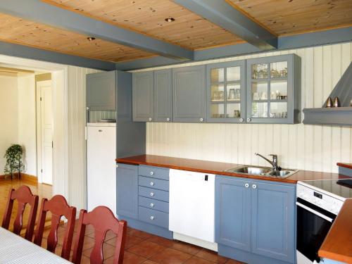 比尔克兰Holiday Home Haven - SOO334 by Interhome的厨房配有蓝色橱柜和白色家电
