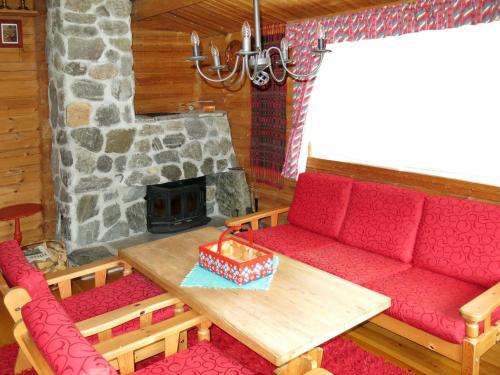 HolsenChalet Fjellbris - FJS106 by Interhome的客厅设有红色的沙发和壁炉