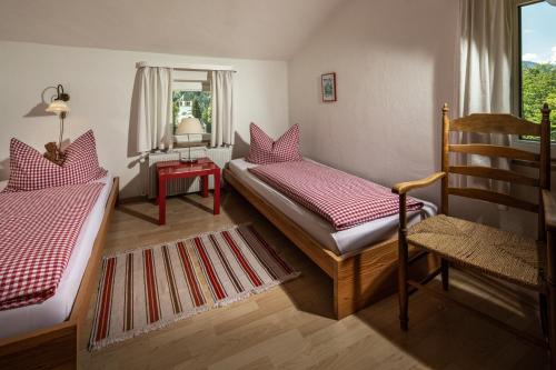 贝希特斯加登Villa Aldefeld的一间卧室设有两张床、一把椅子和一个窗户。